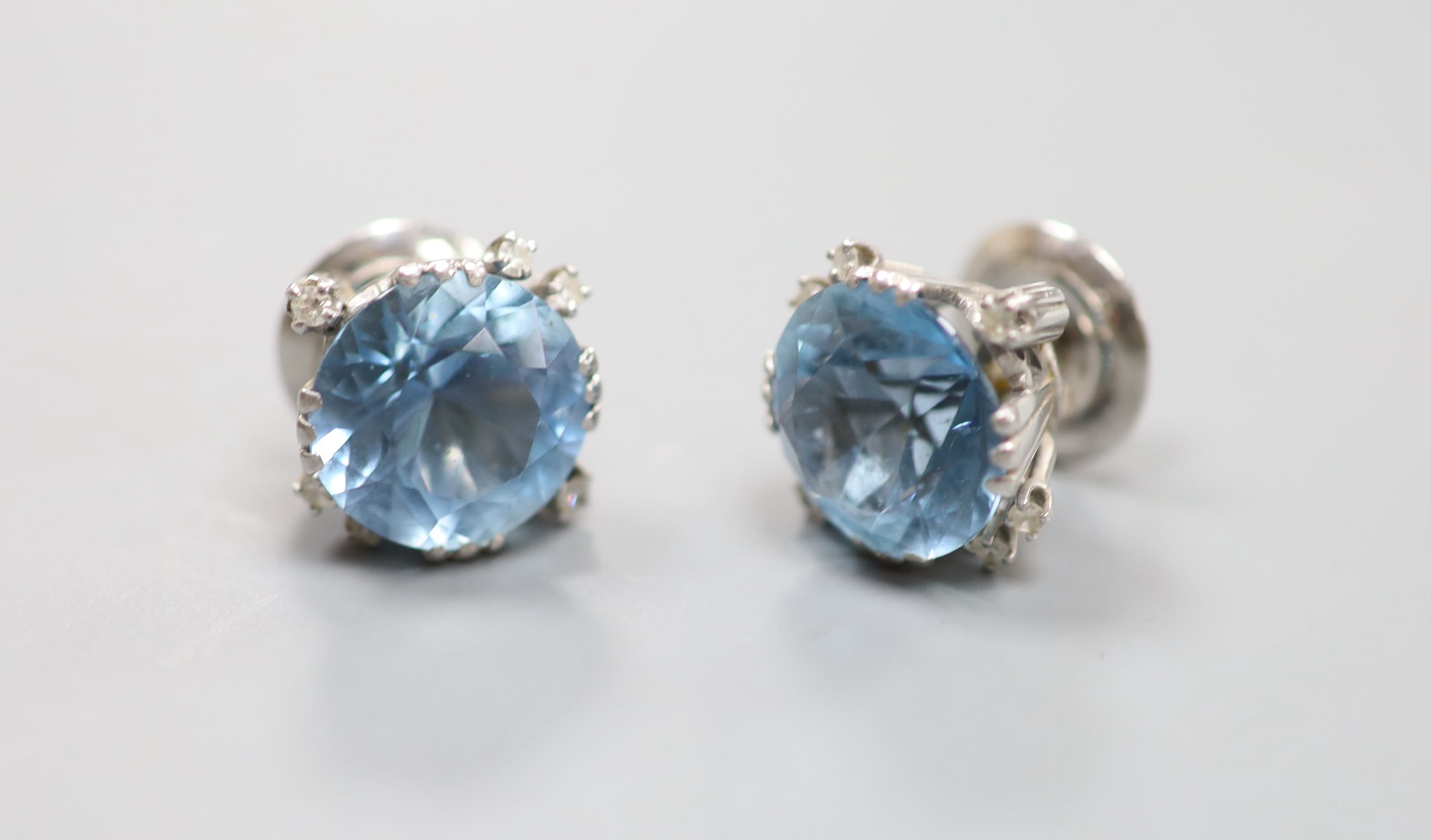 A modern pair of white metal, aquamarine and diamond set ear studs and a matching pendant